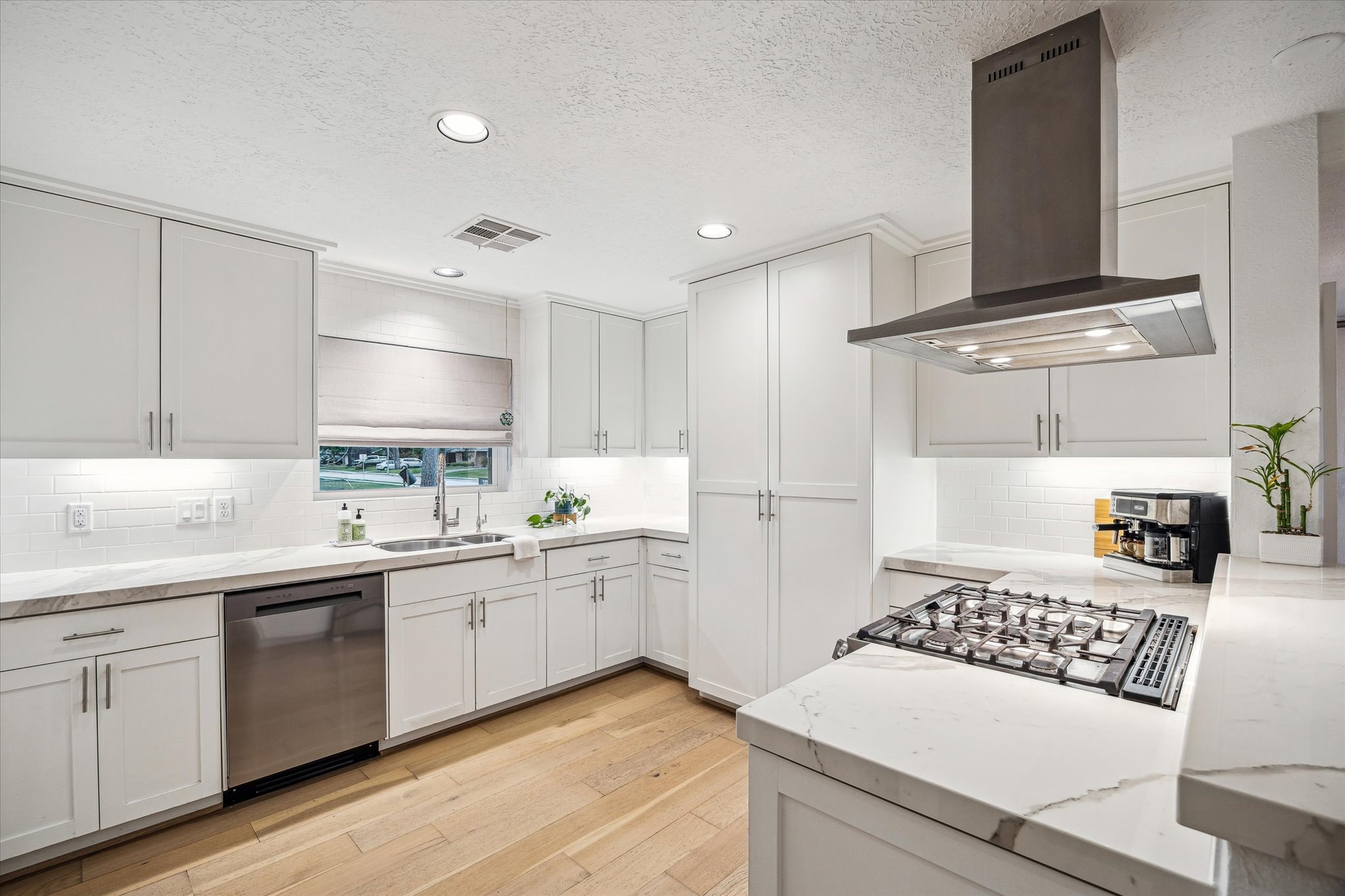 Kitchen with white cabinetry, island seating, and appliances